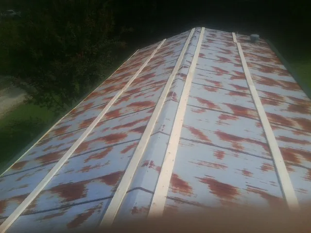 Rusted metal roof panels with new wood purlins before replacement — Storm Damage Roof Repair in Garland by Roofing Brothers