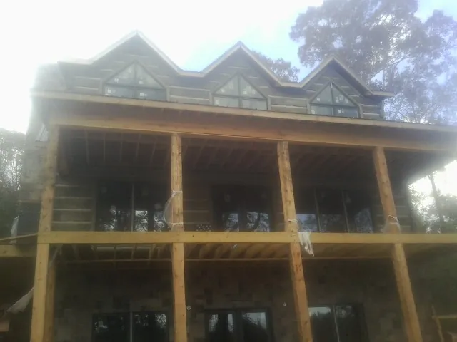 Dormers and porch framing on a large log home under construction in Garland